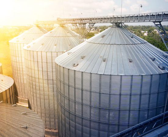 Large metal silos and conveyor belt used for agriculture