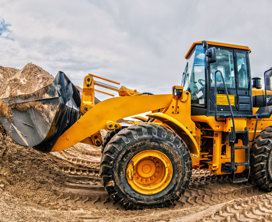 Loader truck scooping dirt at construction site